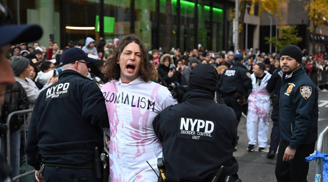 New York Police Department (NYPD) members intervene and take two pro-Palestinian protesters into custody during the traditional Thanksgiving Day parade in New York, United States on November 23, 2023. (Fatih Aktas/Anadolu via Getty Images)