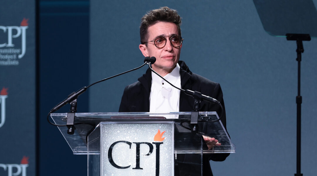 New Yorker journalist Masha Gessen speaks at a lectern with the logo for the Committee to Protect Journalists