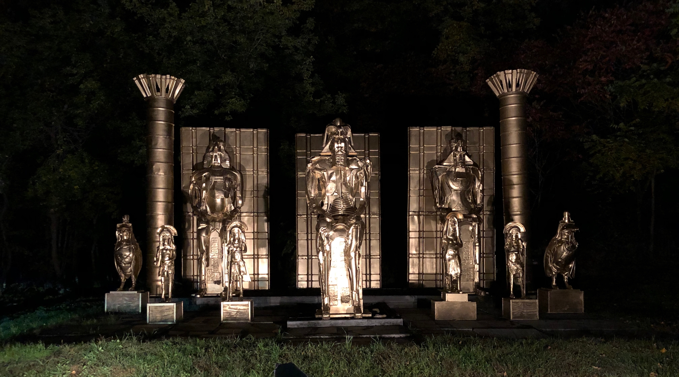 Large Egyptian-themed statues lit up at night