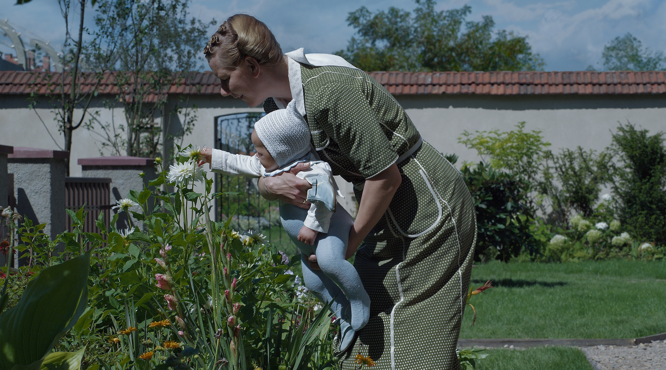 A Nazi mother shows her infant daughter their garden in the shadow of Auschwitz in a still from the movie "The Zone of Interest"