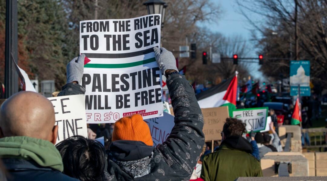 A pro-Palestinian protester holds up a sign reading "From the river to the sea, Palestine will be free" during a rally