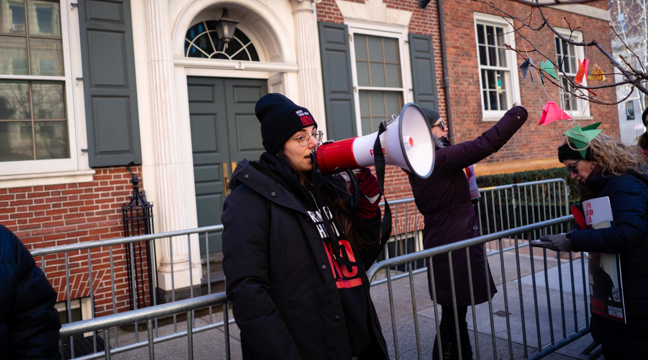 Protest leader Shany Granot-Lubaton leads a crowd outside the home of U.N. Secretary-General Antonio Guterres, January 5, 2024. (Luke Tress)
