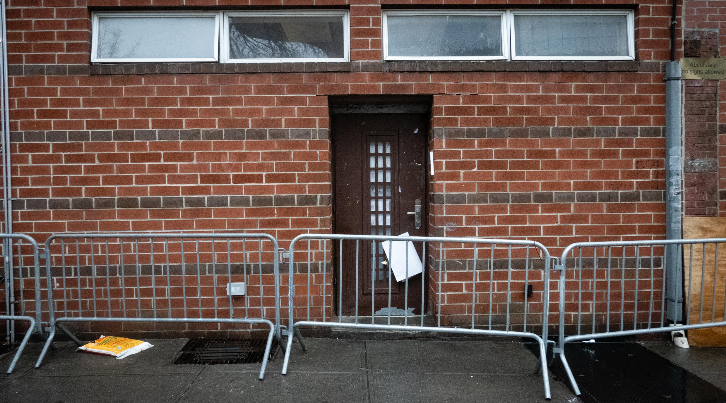 The entrance to a building adjacent to Chabad headquarters that was used for unauthorized excavations, Jan. 9, 2024. A man was seen fleeing from the metal grating to the left of the door during the incident. The grating has since been patched up. (Luke Tress)