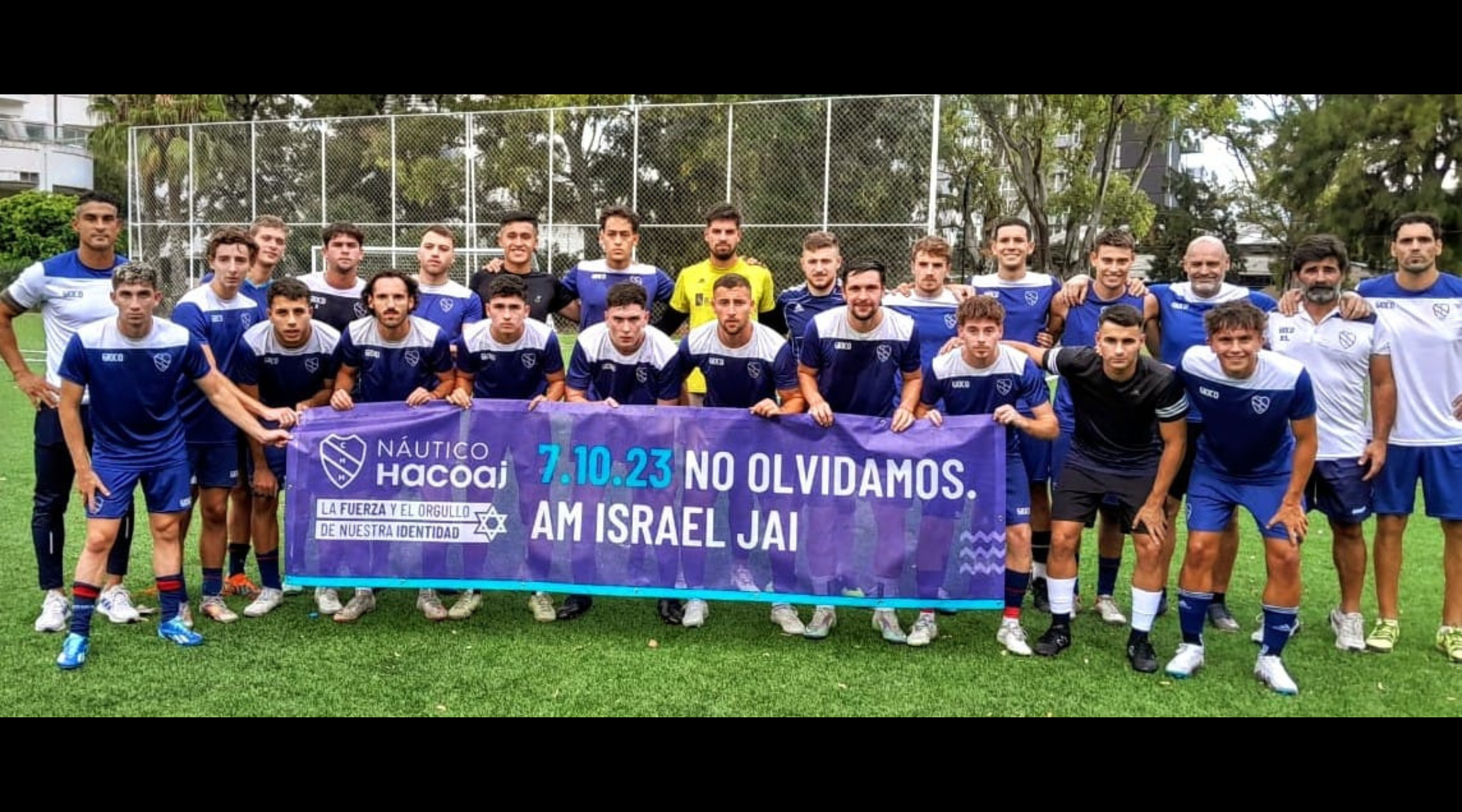 Team posing with banner