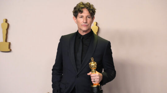 A man holds an Oscar