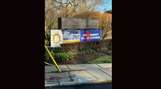 A red swastika painted on a synagogue's pro-Israel sign