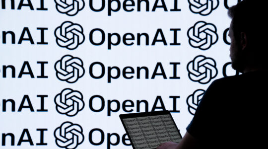 A laptop open in front of an illustration of the OpenAI logo
