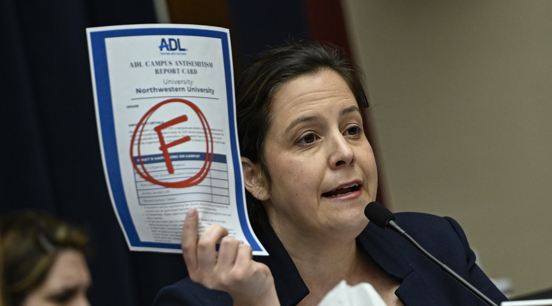 A member of Congress holds up an "F" grade from an Anti-Defamation League "report card"