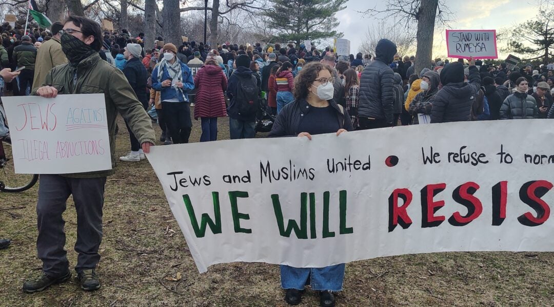 Jews at a rally holding signs reading "Jews and Muslims United" and "Jews Against Illegal Abductions"