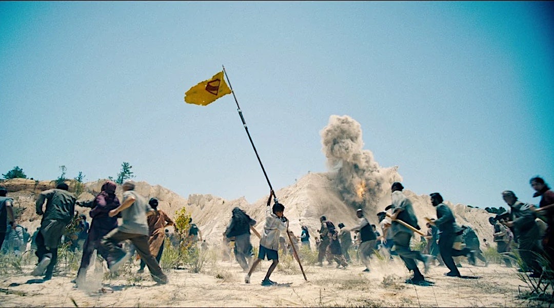 A child waves a flag during a scene from the 2025 movie "Superman."