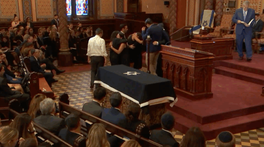 Family and friends of Julia Hyman hug during her funeral