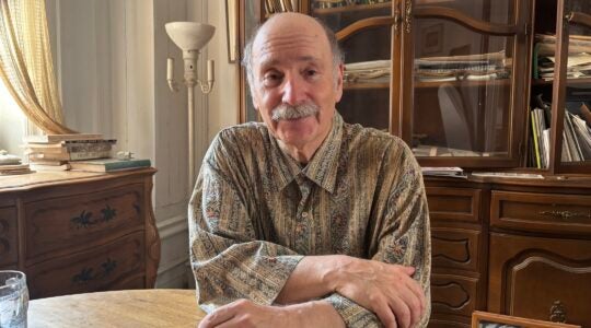 Walter Zev Feldman sits in front of a bookcase