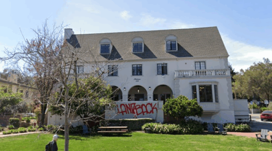 A photo of the kairos co-op house at stanford. It is a three story white building.