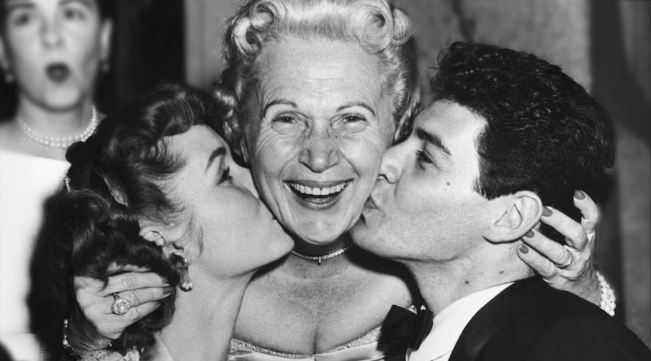 Jennie Grossinger, proprietor of Grossinger's Catksills Resort, is flanked by Debbie Reynolds and Eddie Fisher, who are both kissing her on her cheeks