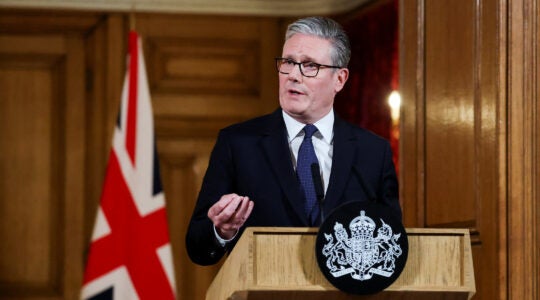 A photo of Kier Starmer speaking in front of a British flag.