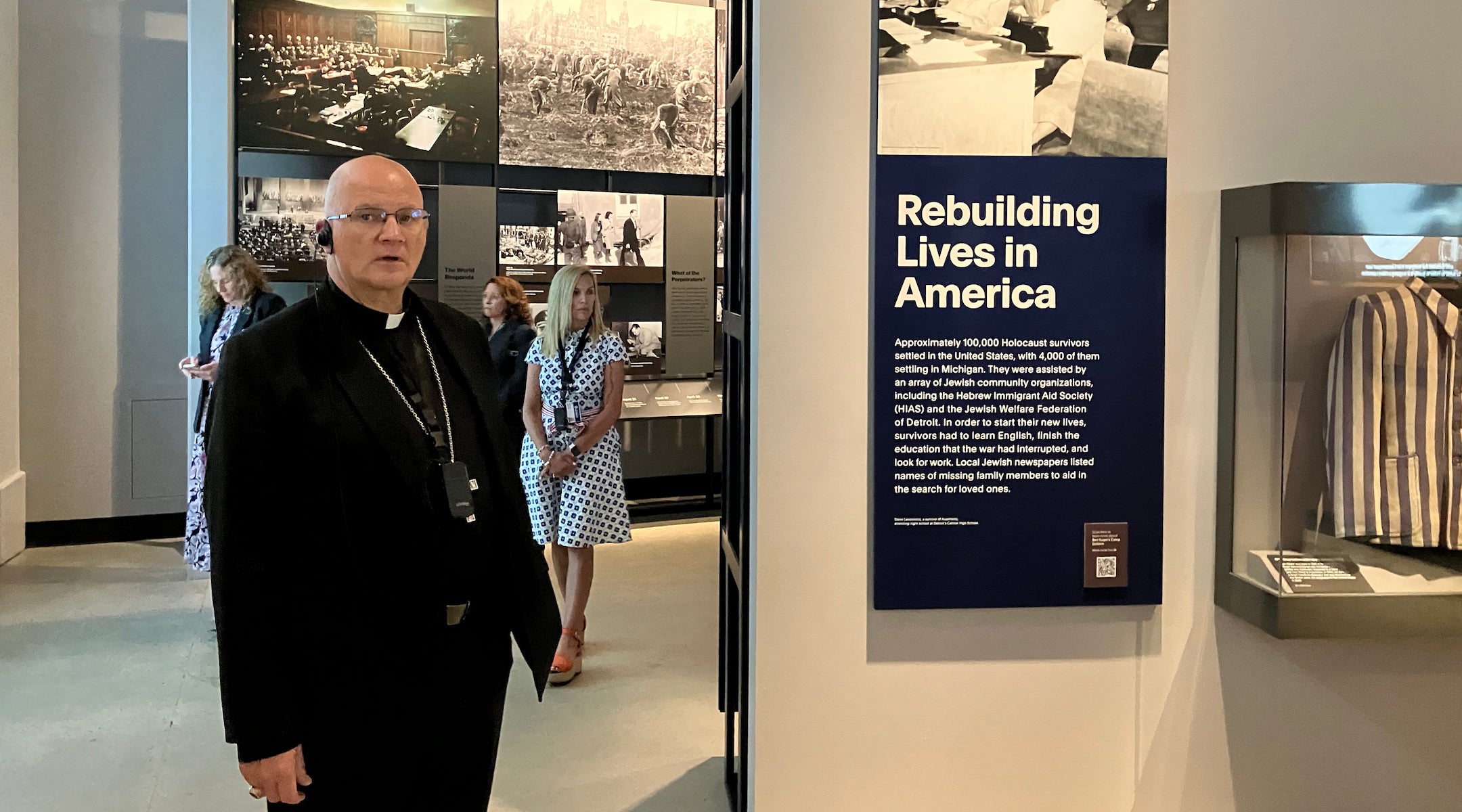A bishop examines exhibits in a Holocaust museum