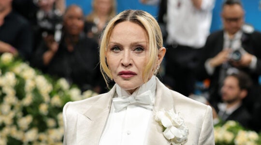 A photo of Madonna on the red carpet in a white suit.