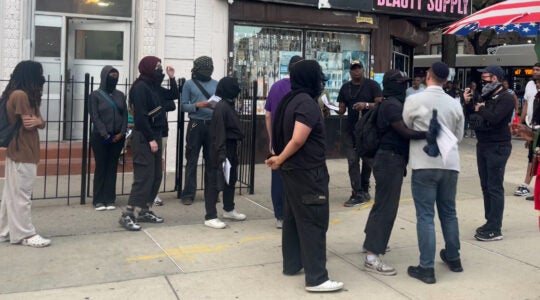 A photo of a group of protestors confronting a Jewish man.