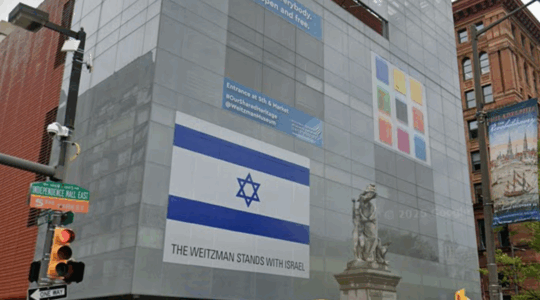 A photo of the facade of the The Weitzman National Museum of American Jewish History in Philadelphia with the Israeli flag.