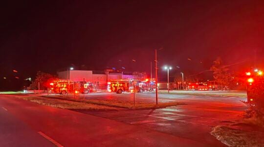 A photo of fire trucks with red lights.