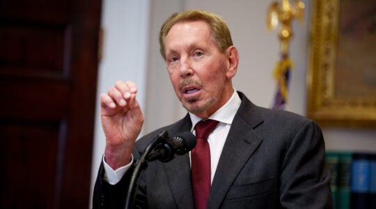 A photo of Larry Ellison speaking from a podium.