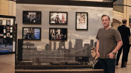 Abe Kugielsky in front of his photography.