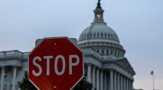 A photo of the Capitol with a stop sign in front of it.