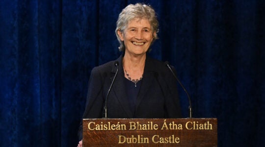 A photo of Connolly speaking from a podium and smiling.