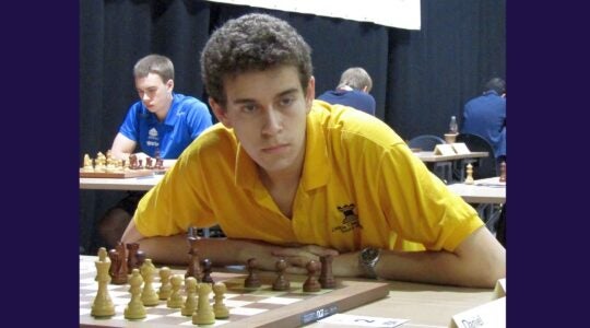 A photo of Daniel Naroditsky looking intently at a chess game.