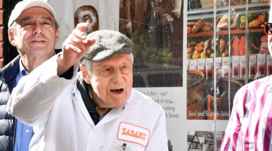 Saul Sabar waves while wearing a Zabar's uniform.